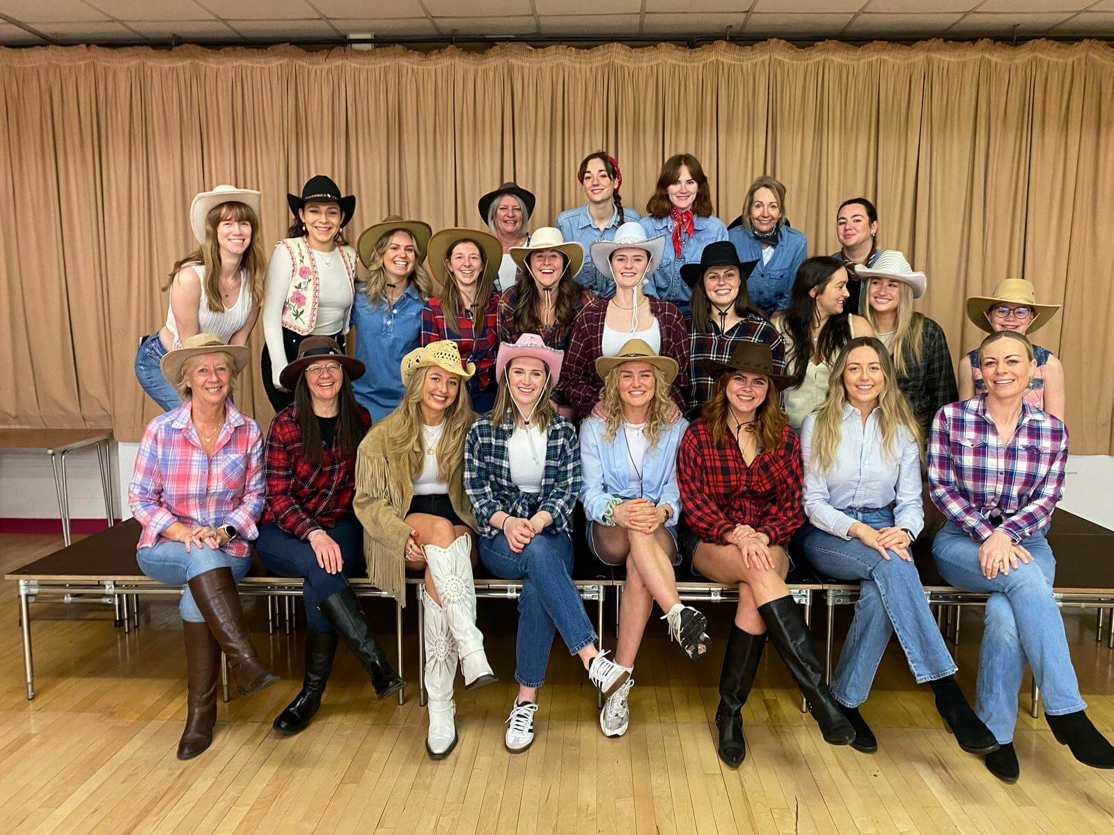 Durham line dancing hen party with expert instructor teaching country western moves to group wearing cowboy hats near historic cathedral